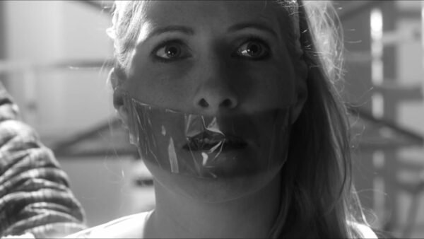 A woman is kidnapped taped to a chair and tape gagged in Plak Band Short Film - Thumbnail